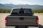 Vehicle decal with a silhouette of a deer and mountains.
